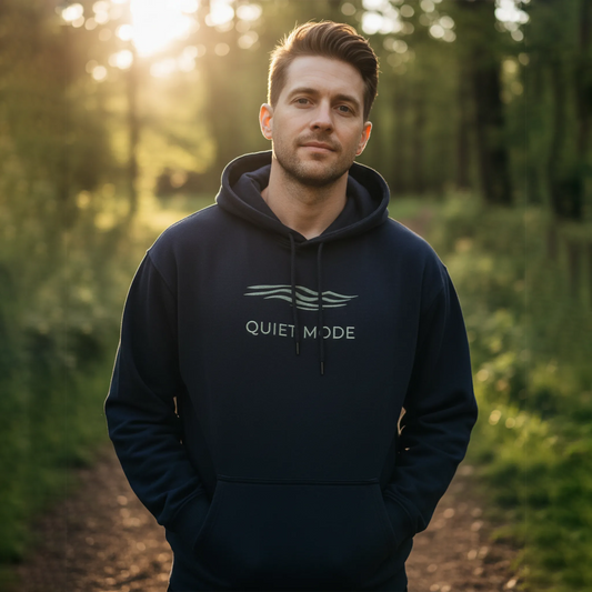Man wearing a hoodie with 'Quiet Mode' text in a forest setting