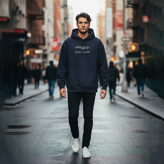 Man wearing a hoodie with 'The Quiet Life' logo on a city street.